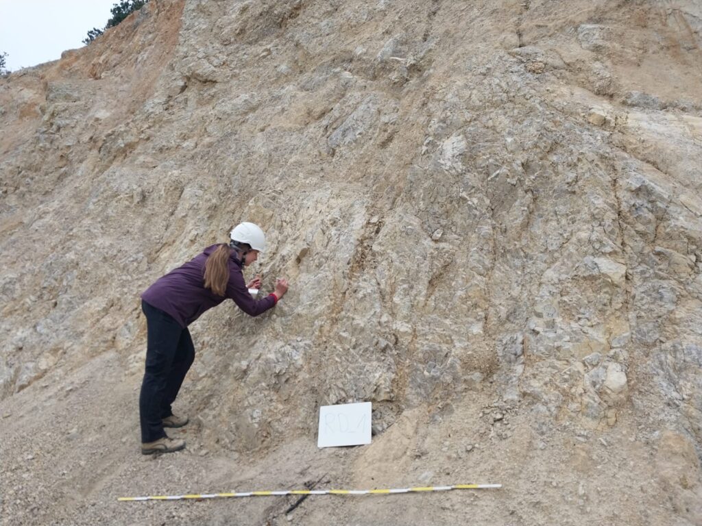 Woman measuring rock fractures in the field.